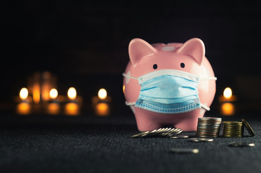 person saving coins in piggy bank