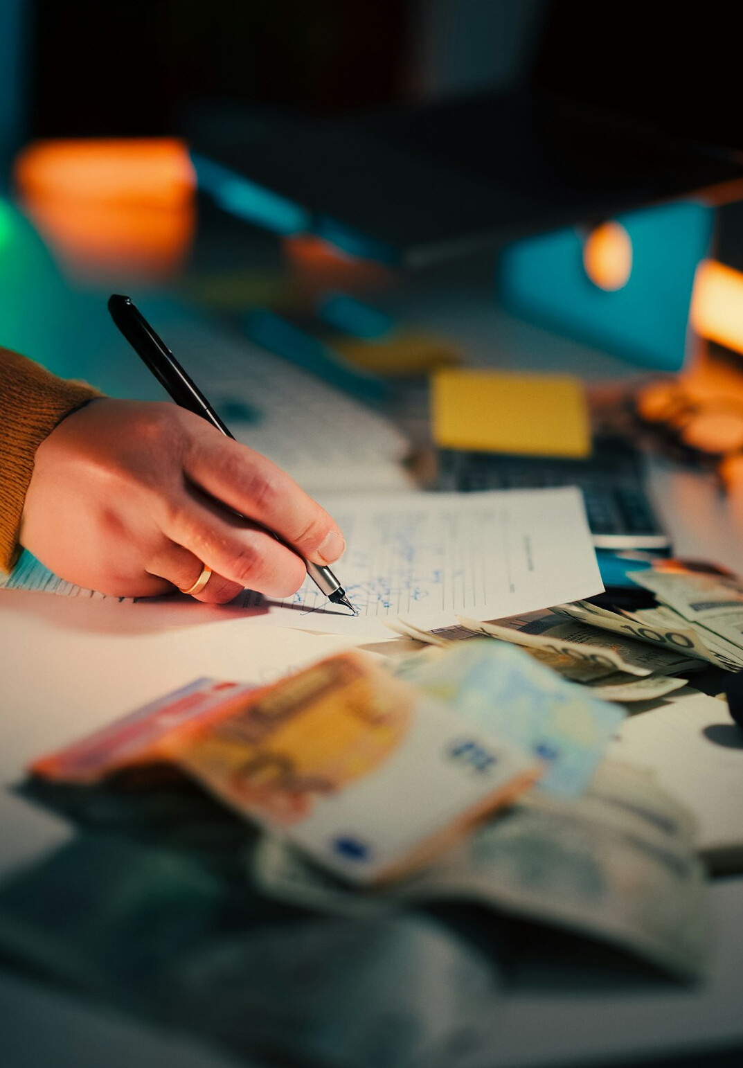 person writing financial goals on paper